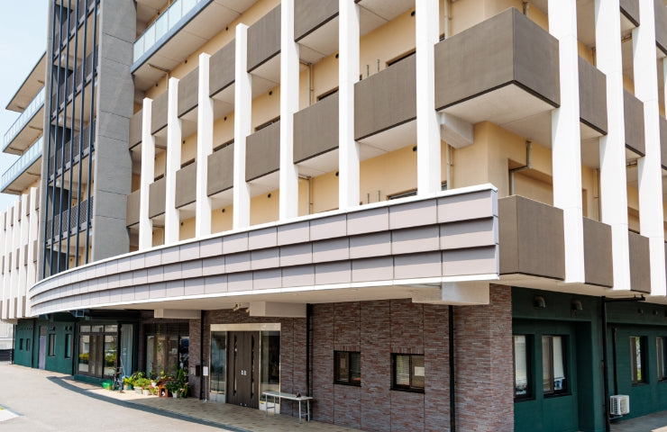 モダンデザインの介護施設建物外観。白と茶色のツートンカラーで統一された立派な建物です。